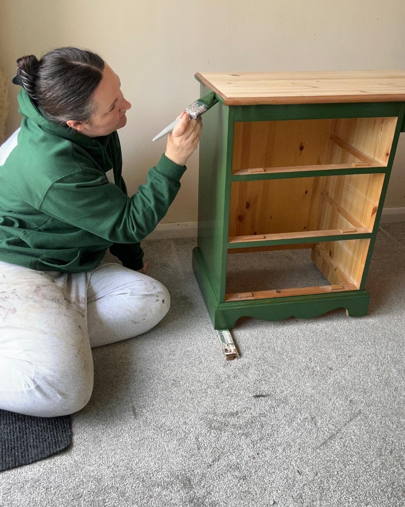 A bedside cabinet being hand-painted green by Redo & Renew