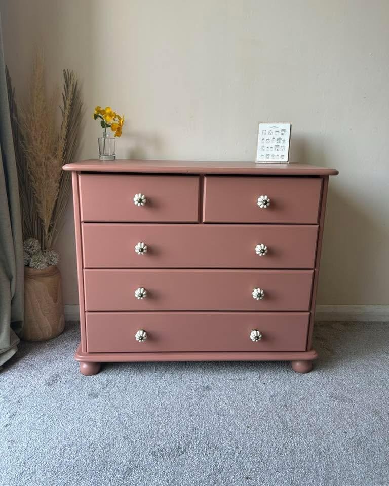 A chest of drawers renewed in dusky pink with floral knobs